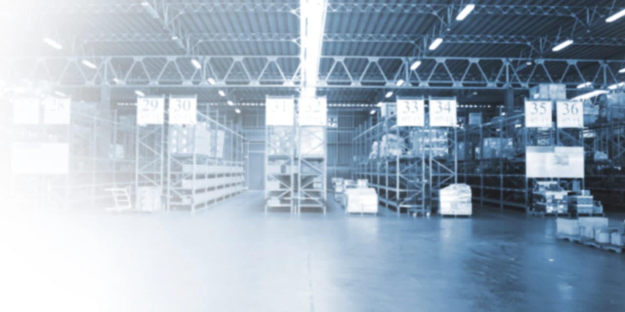 Interior de una bodega industrial con estanterías de almacenamiento y pasillos numerados