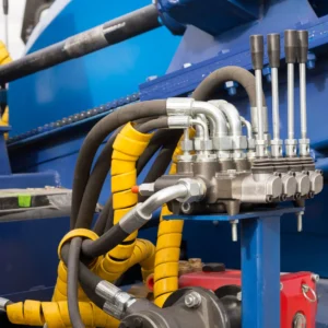 Hydraulic tubes, fittings and levers on control panel, close up of pipe system
